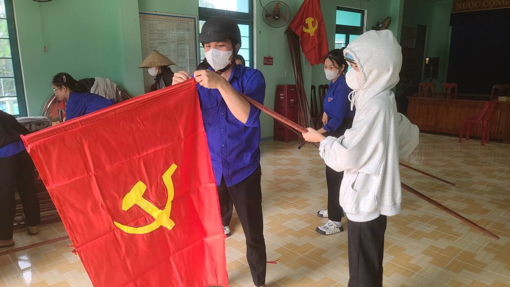 A group of people holding a flag Description automatically generated