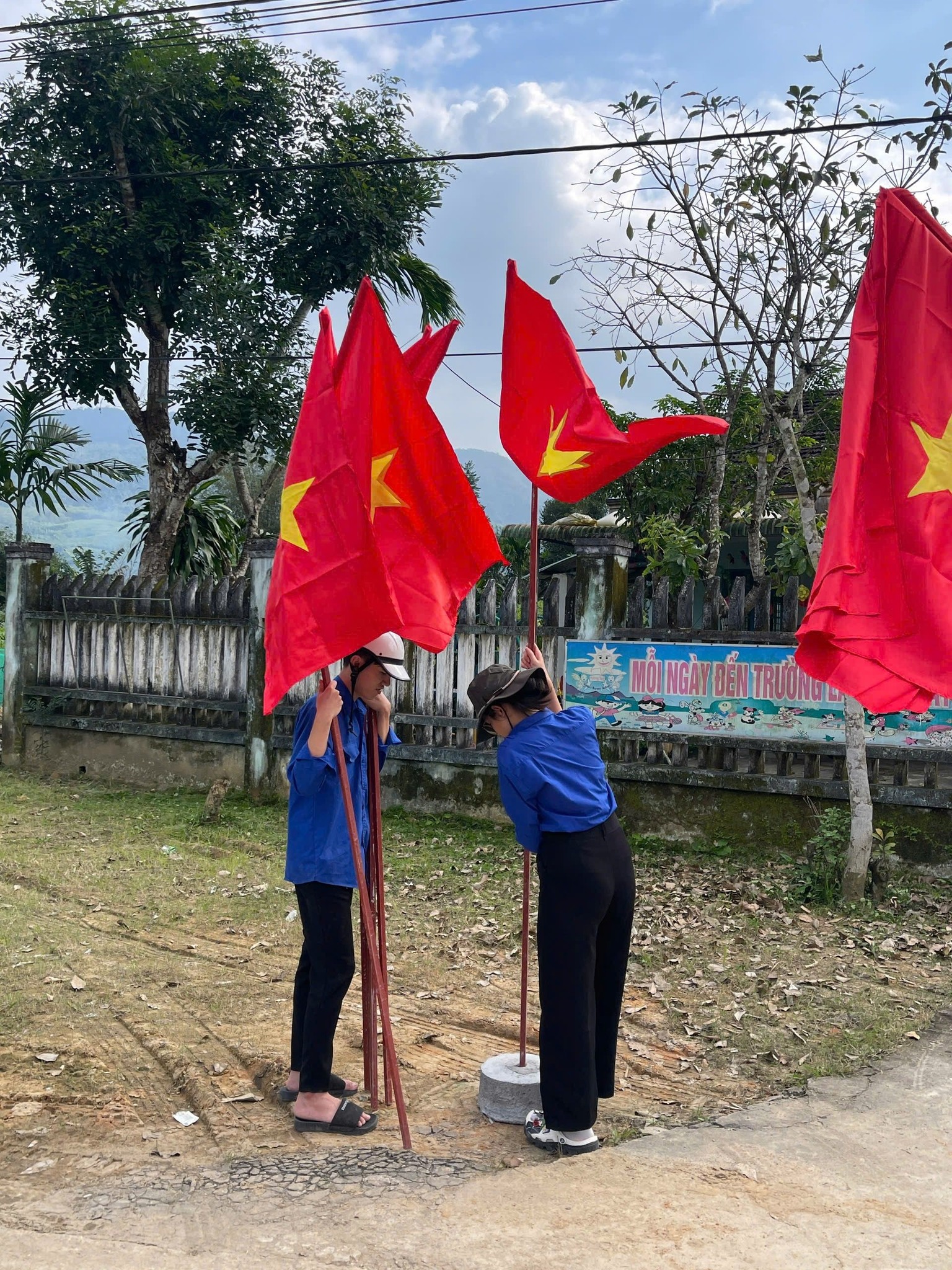 A group of people holding red flags Description automatically generated