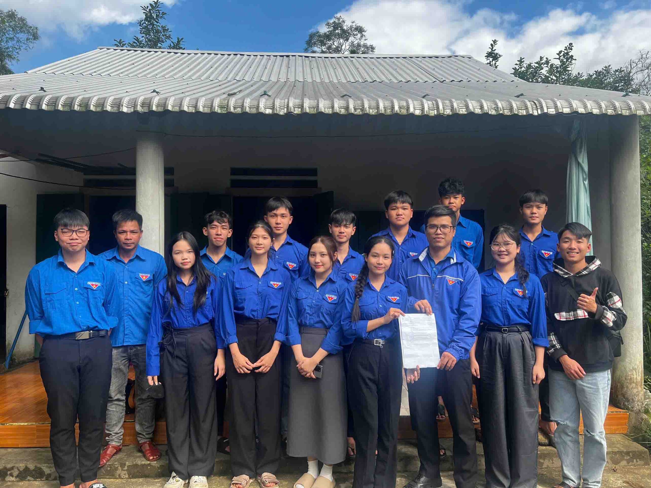 A group of people standing in front of a building Description automatically generated