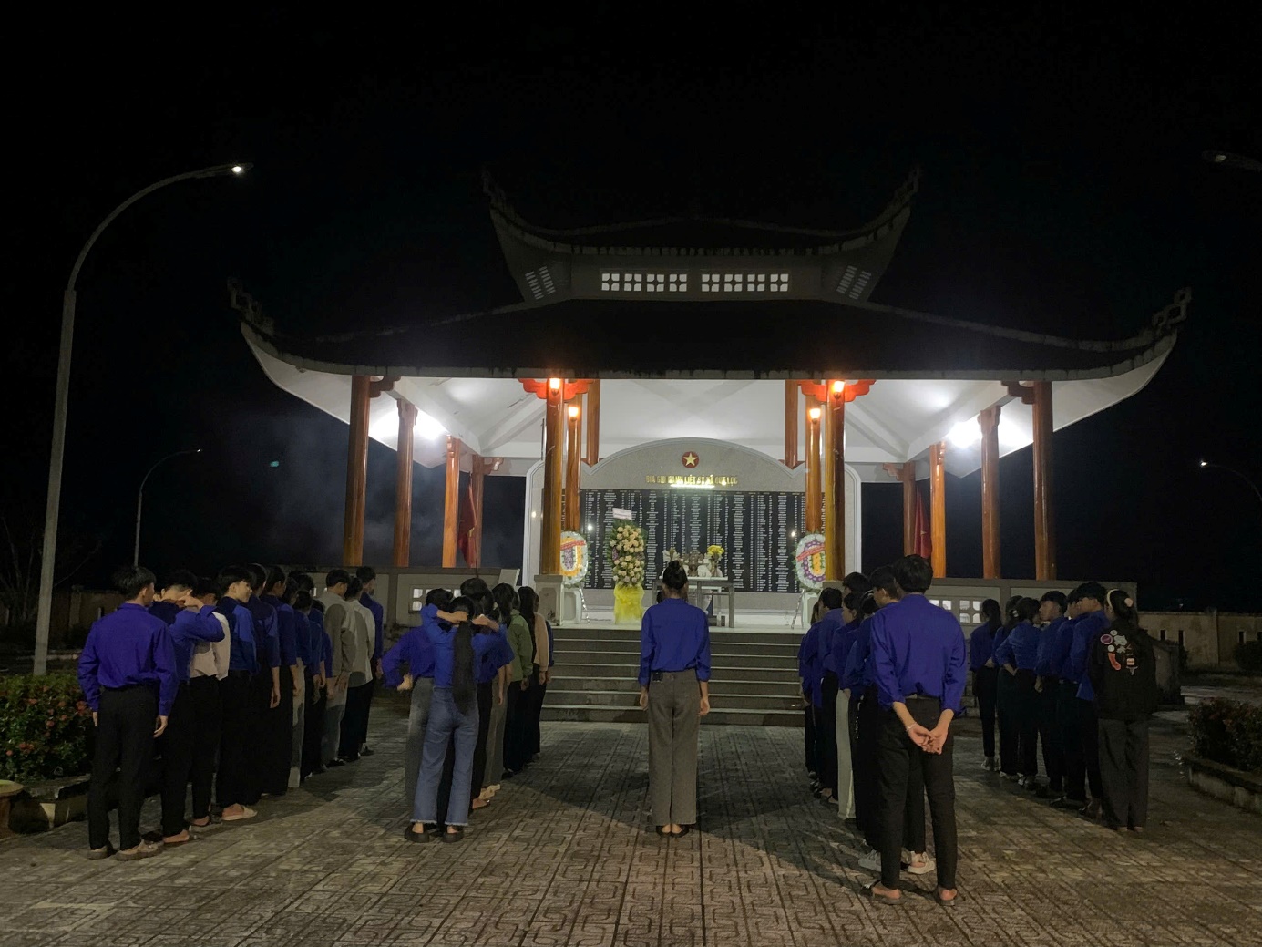 A group of people standing in front of a building

Description automatically generated