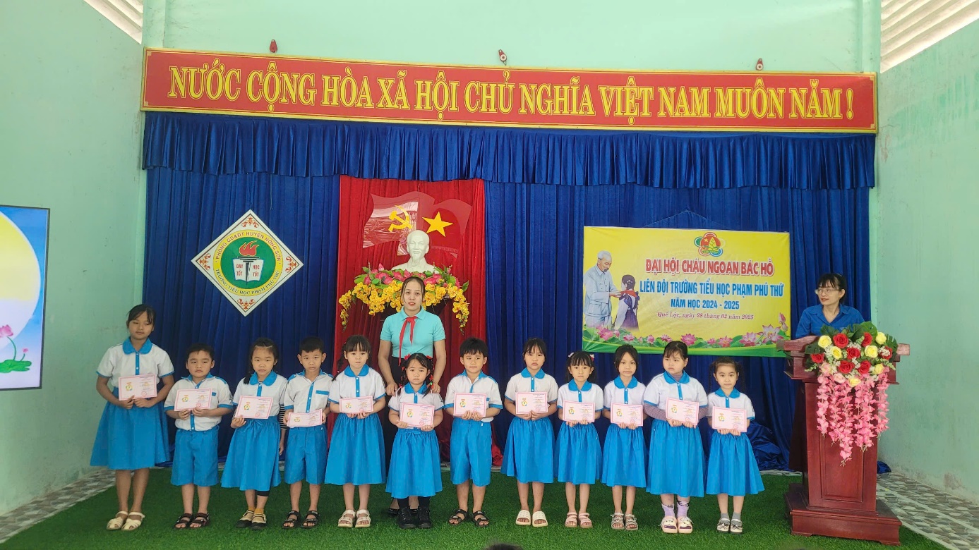 A group of children standing in front of a stage Description automatically generated