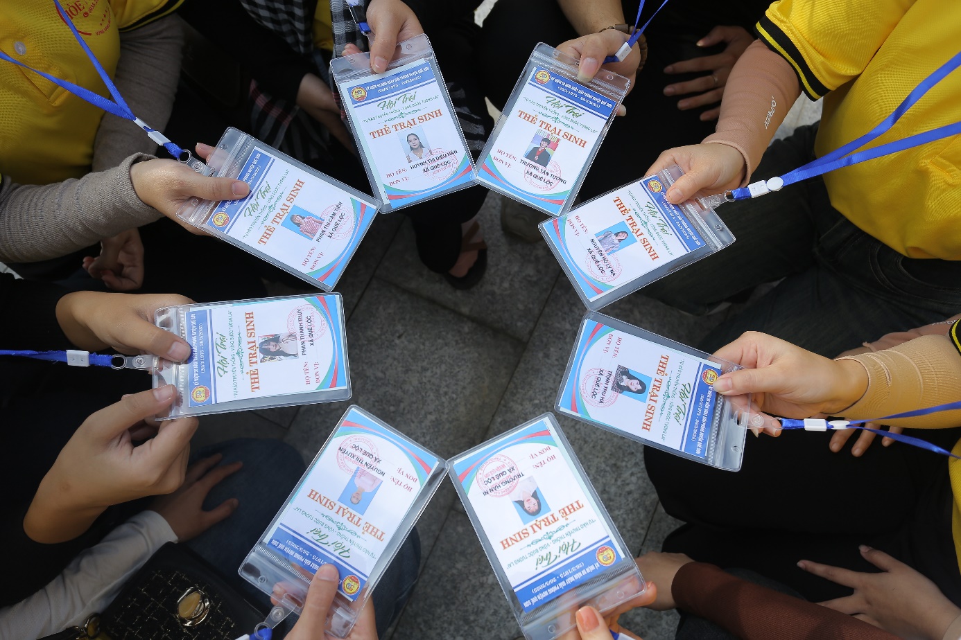 A group of people holding id cards Description automatically generated